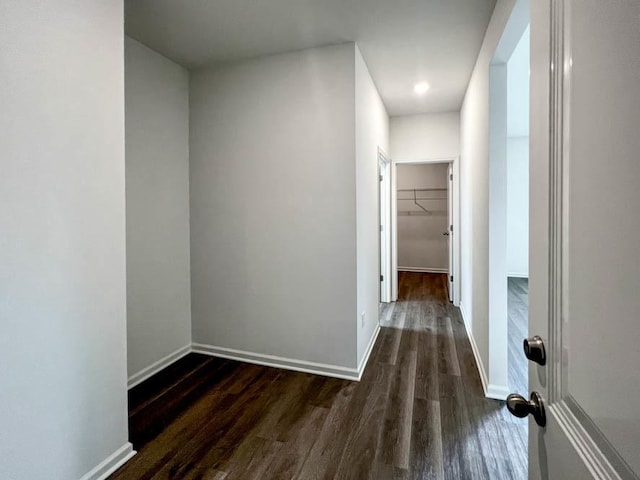 hallway with dark wood-style flooring and baseboards