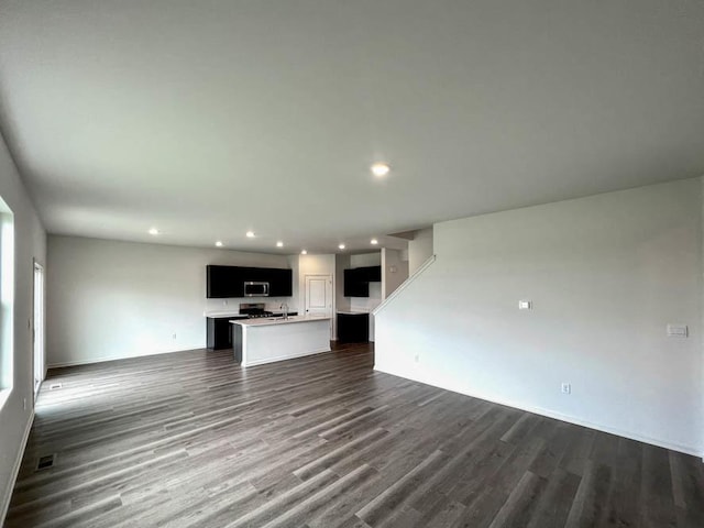 unfurnished living room with dark wood-style floors, visible vents, and recessed lighting