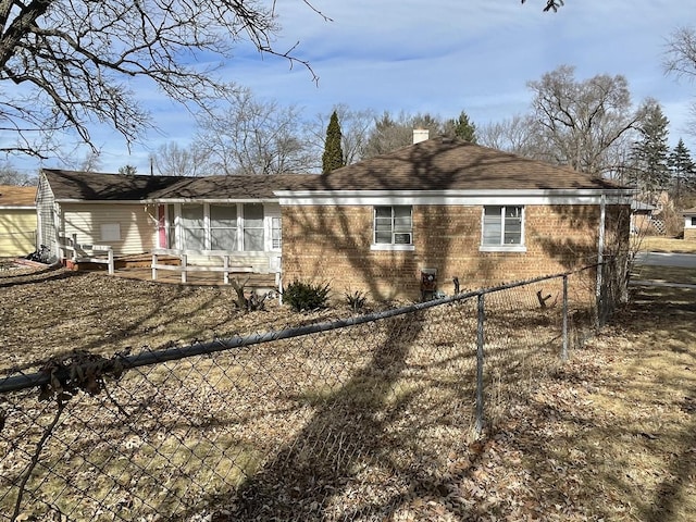 view of home's exterior with brick siding, a chimney, and fence