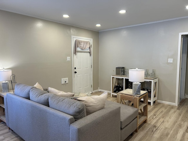 living room with light wood-type flooring, crown molding, baseboards, and recessed lighting