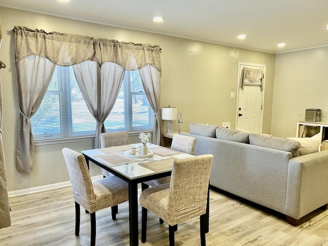 dining area featuring plenty of natural light, light wood-type flooring, and crown molding