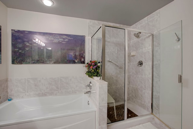 full bathroom featuring a bath and a stall shower