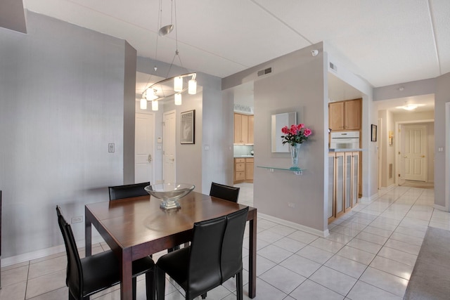 dining area featuring light tile patterned floors, visible vents, and baseboards