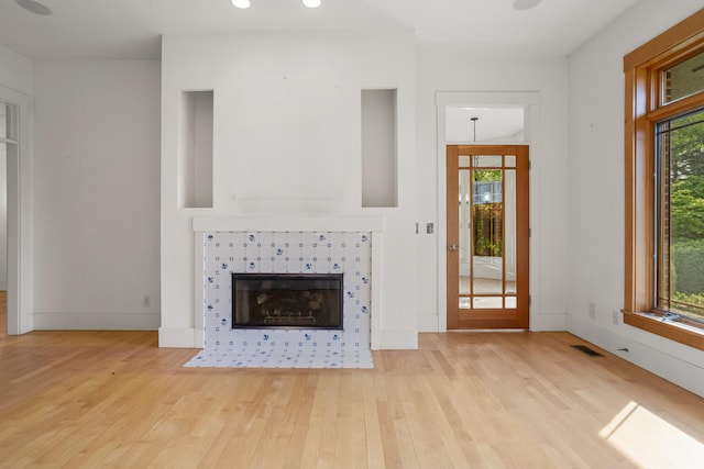 2806 Oakmont Ct, Champaign, IL 61821 - unfurnished living room featuring light wood-style floors, healthy amount of natural light, a tiled fireplace, and recessed lighting