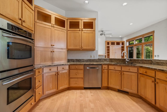 2806 Oakmont Ct, Champaign, IL 61821 - kitchen with appliances with stainless steel finishes, a sink, recessed lighting, light wood-type flooring, and dark stone countertops