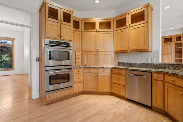 2806 Oakmont Ct, Champaign, IL 61821 - kitchen featuring stainless steel appliances, light wood finished floors, tasteful backsplash, dark stone counters, and glass insert cabinets