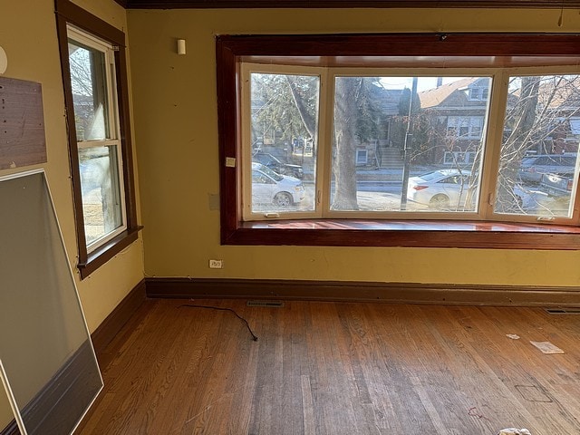 spare room featuring baseboards and wood finished floors