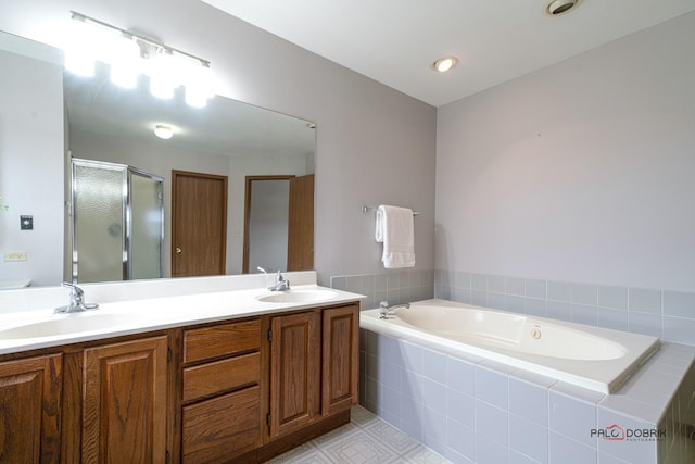 full bathroom with double vanity, a stall shower, a garden tub, and a sink