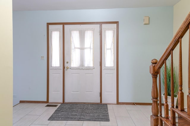 foyer with visible vents, stairway, and baseboards