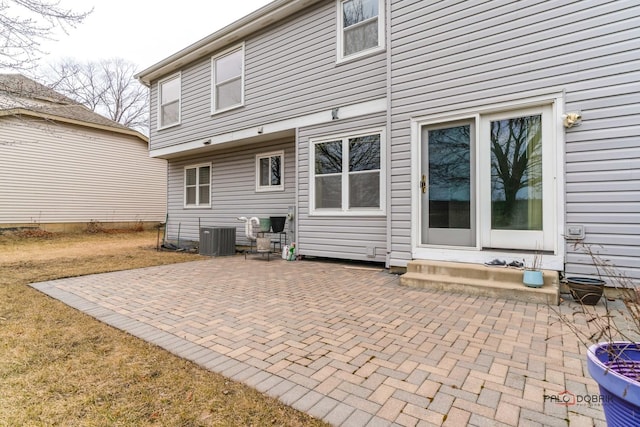 rear view of house featuring central AC unit and a patio