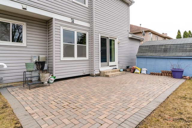 view of patio with entry steps, an outdoor structure, and a storage shed