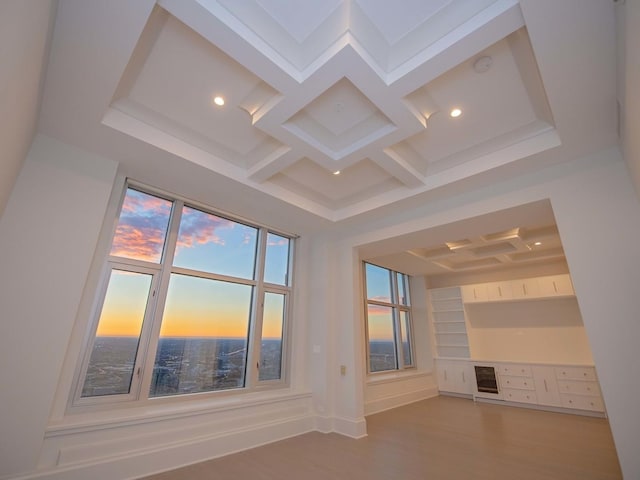 unfurnished living room featuring baseboards, coffered ceiling, wood finished floors, beamed ceiling, and recessed lighting