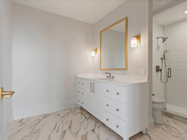 bathroom with marble finish floor, a shower stall, baseboards, and vanity