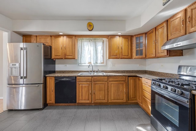 kitchen featuring a sink, appliances with stainless steel finishes, brown cabinets, and under cabinet range hood