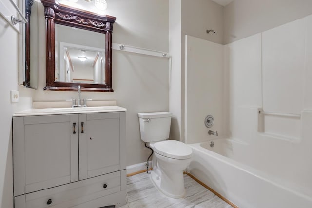 full bathroom with toilet, wood finished floors, vanity, baseboards, and shower / washtub combination