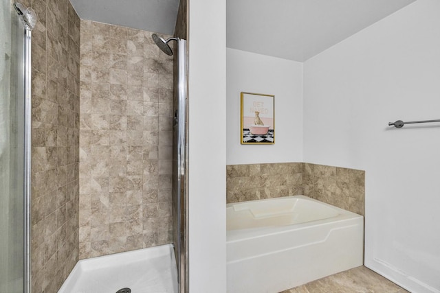 bathroom with a stall shower and a garden tub