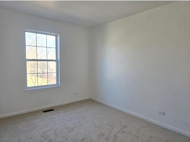 carpeted empty room with visible vents and baseboards