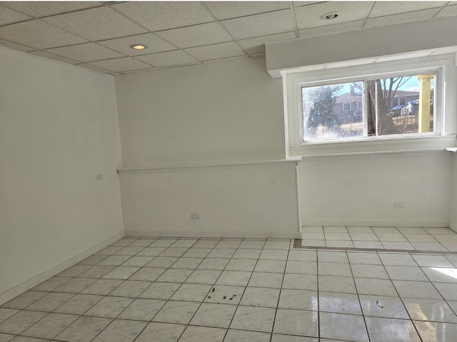 spare room featuring recessed lighting, a drop ceiling, baseboards, and light tile patterned flooring