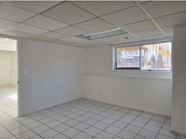 unfurnished room featuring a paneled ceiling, visible vents, and baseboards