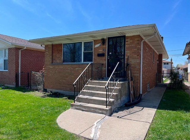 view of front of property with brick siding, a front yard, and fence