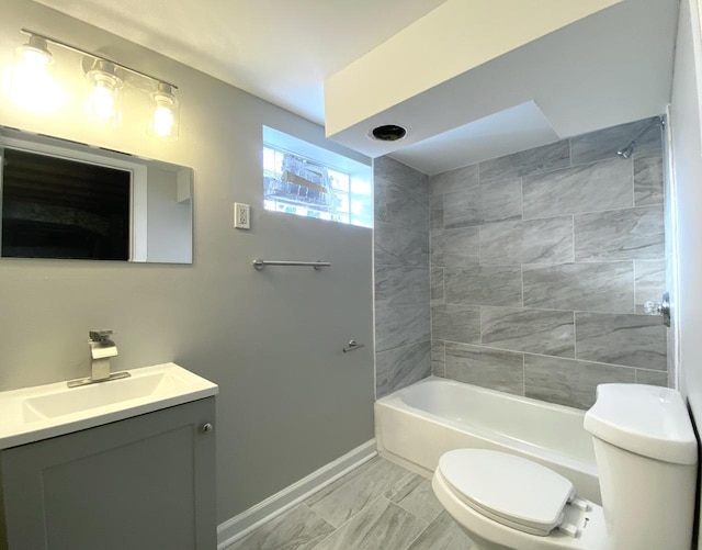 bathroom featuring vanity, toilet, tub / shower combination, and baseboards