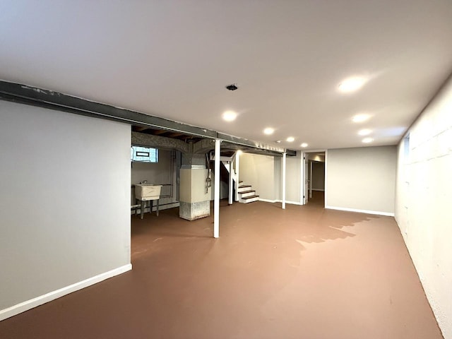 finished basement with stairs, recessed lighting, baseboards, and a sink