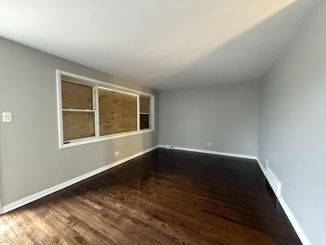 empty room featuring wood finished floors and baseboards