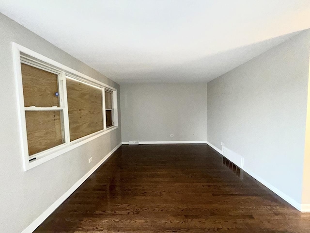 unfurnished room featuring baseboards and wood finished floors