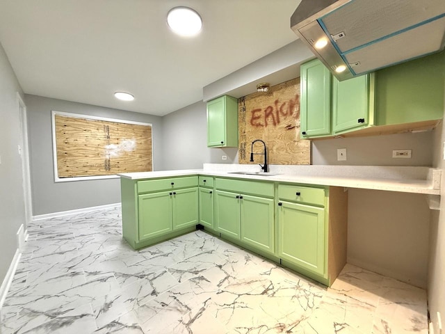 kitchen featuring green cabinets, light countertops, marble finish floor, and a sink