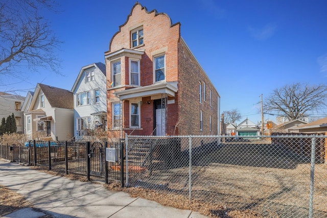 view of front of property featuring brick siding, a fenced front yard, and a residential view