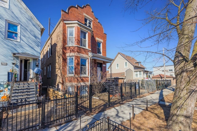 view of front of home with a fenced front yard and brick siding