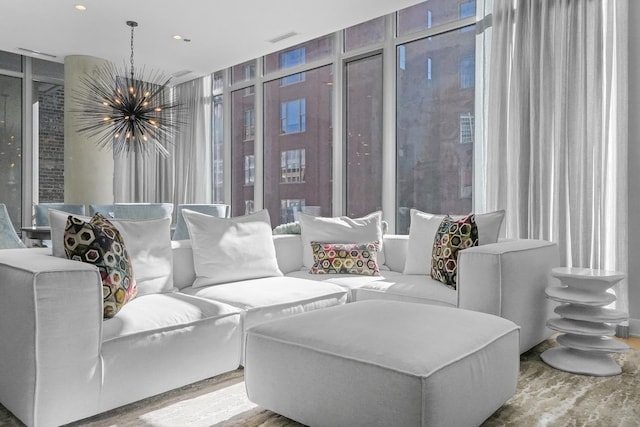 living room with a wall of windows, visible vents, and an inviting chandelier