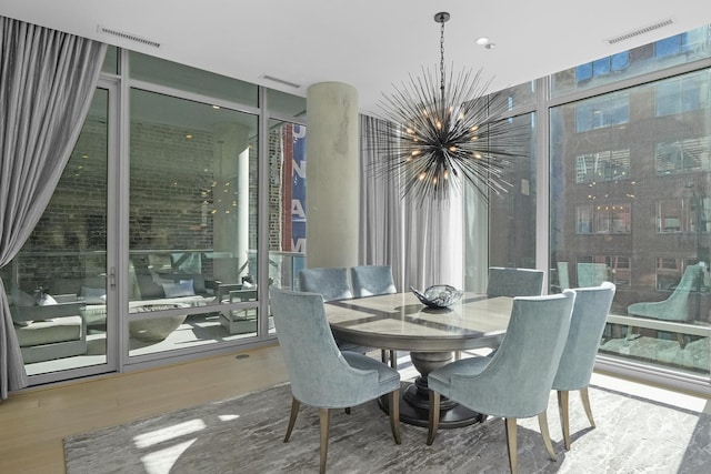 dining area with expansive windows, wood finished floors, visible vents, and an inviting chandelier