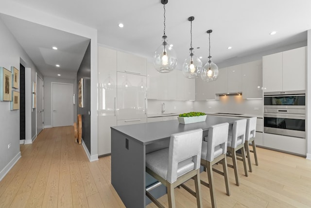 kitchen featuring light wood-style floors, white cabinets, and modern cabinets