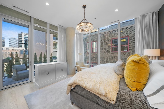 bedroom with recessed lighting, visible vents, access to outside, hardwood / wood-style floors, and a wall of windows