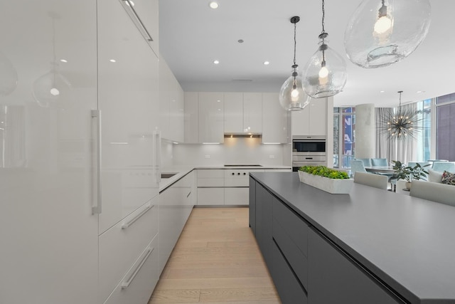 kitchen featuring cooktop, light wood-type flooring, modern cabinets, and white cabinets