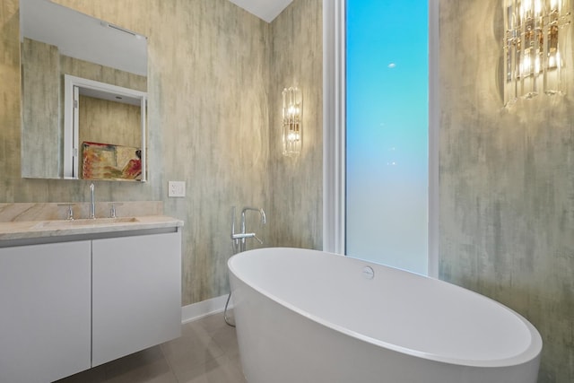 full bathroom featuring a freestanding tub, vanity, and tile patterned floors