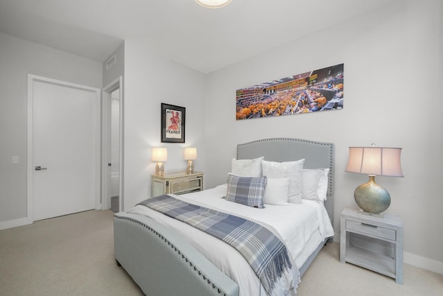 bedroom with baseboards and light colored carpet