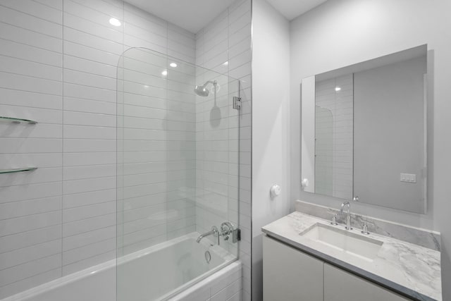 bathroom with tiled shower / bath and vanity