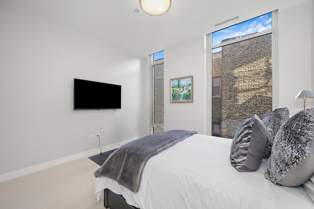 carpeted bedroom featuring floor to ceiling windows, visible vents, and baseboards