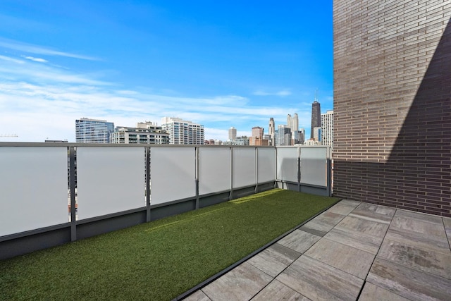 view of yard with a balcony and a view of city