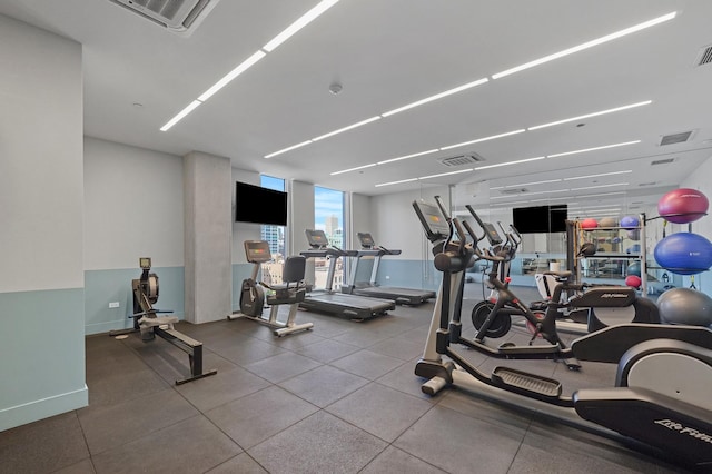 gym featuring a wall of windows, visible vents, and baseboards