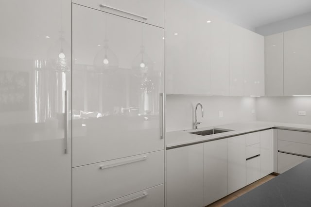 kitchen featuring light countertops, white cabinets, a sink, and modern cabinets