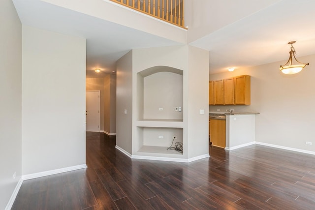 87 E Haines Dr Unit 87, Hainesville, IL 60030 - unfurnished living room featuring baseboards, dark wood-style floors, built in shelves, and arched walkways
