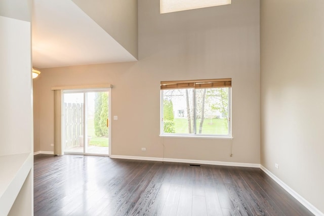 87 E Haines Dr Unit 87, Hainesville, IL 60030 - unfurnished living room with baseboards, dark wood finished floors, a high ceiling, and a wealth of natural light