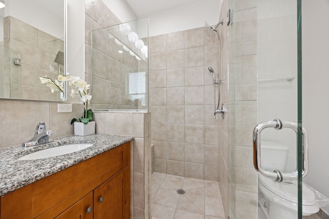 full bathroom featuring backsplash, a shower stall, tile walls, toilet, and vanity