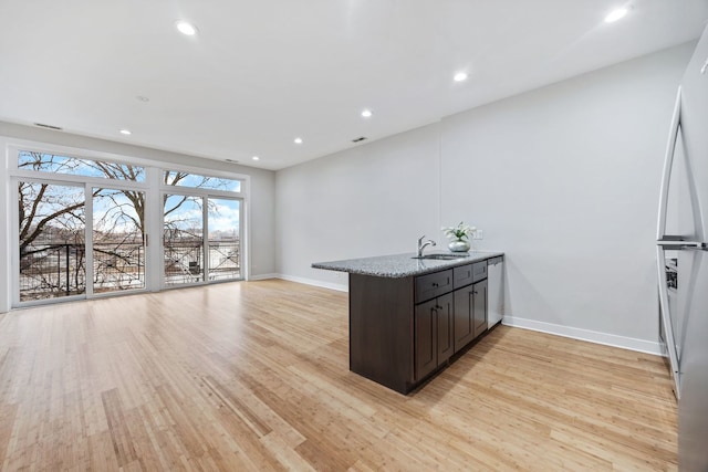 kitchen with light wood-type flooring, a sink, recessed lighting, appliances with stainless steel finishes, and dark brown cabinets