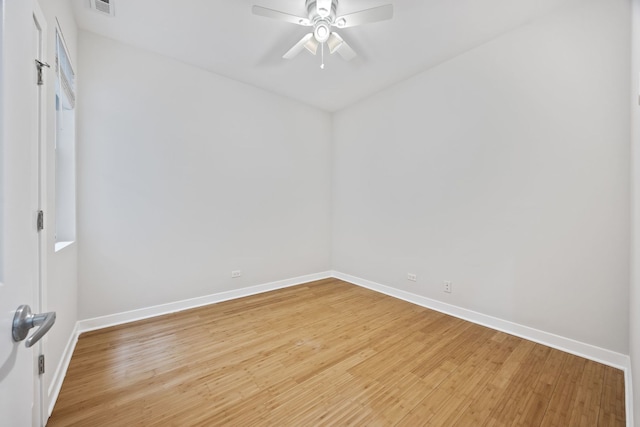 spare room featuring baseboards, light wood-style floors, and a ceiling fan