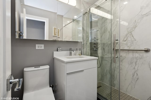 full bath with vanity, a marble finish shower, and toilet