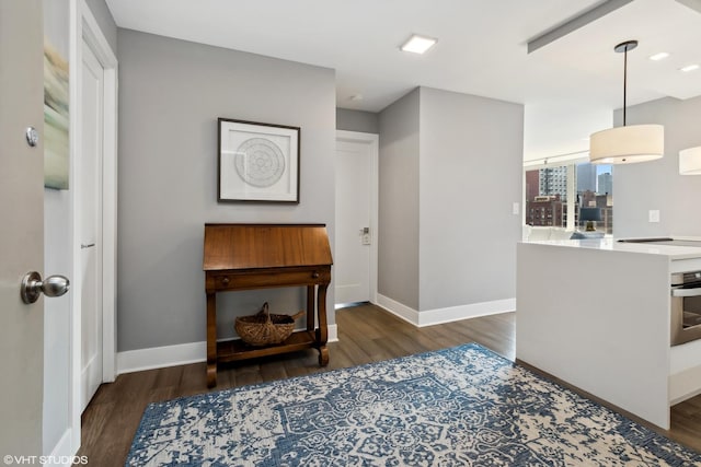 living area with baseboards and wood finished floors